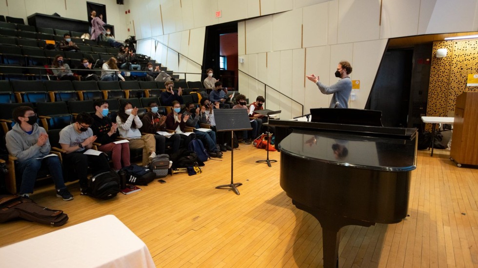 Eric Nathan and students clapping together in an auditorium