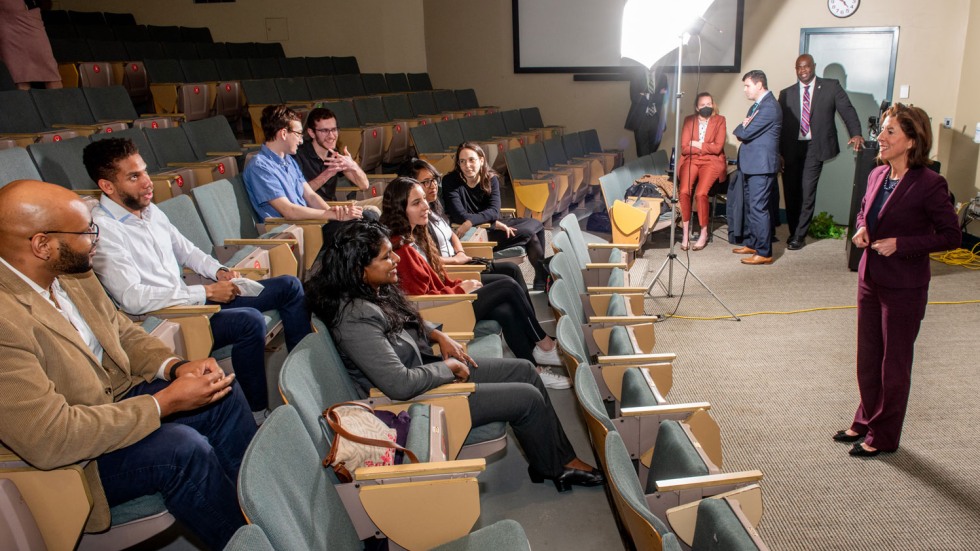 Woman speaking with students in a raked auditorium