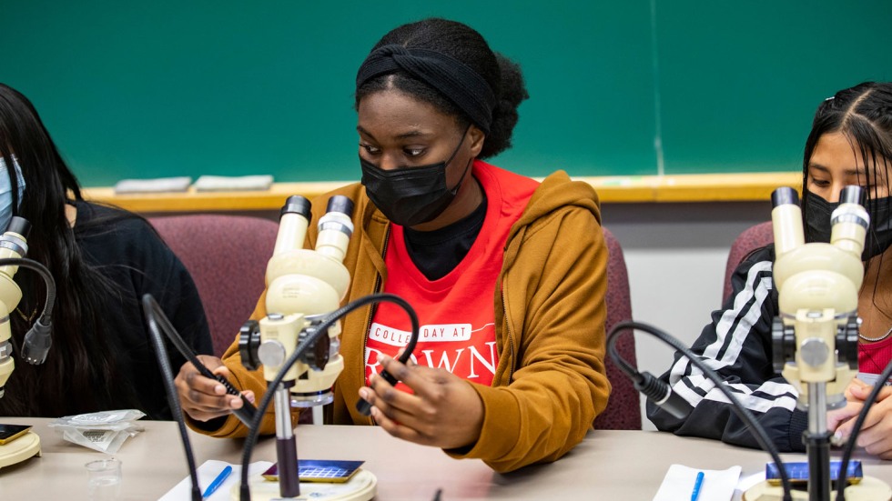 student using a microscope in a classroom