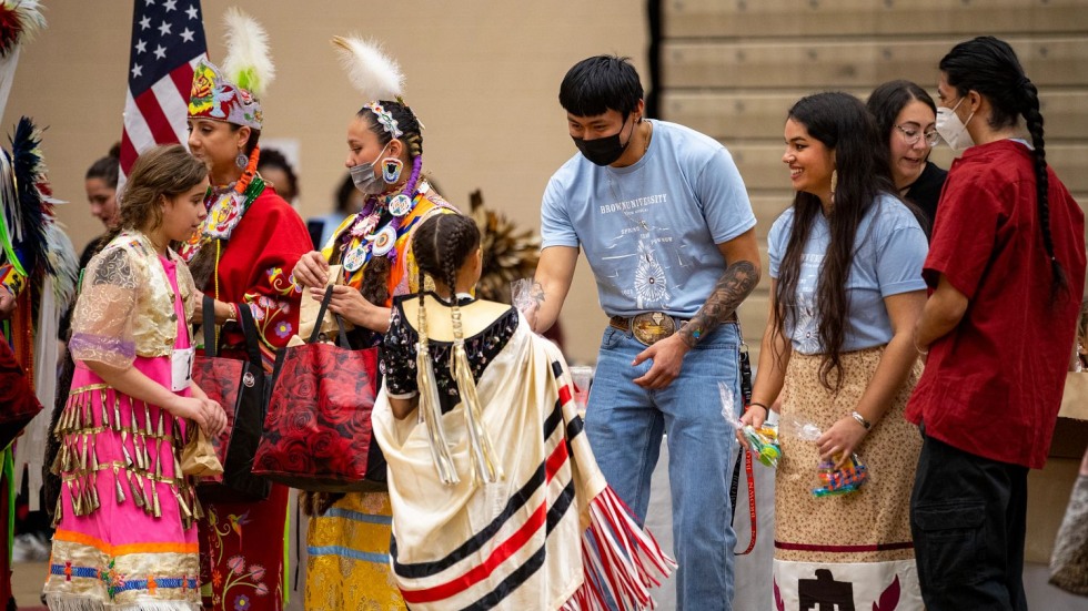 adults handing out candy to children