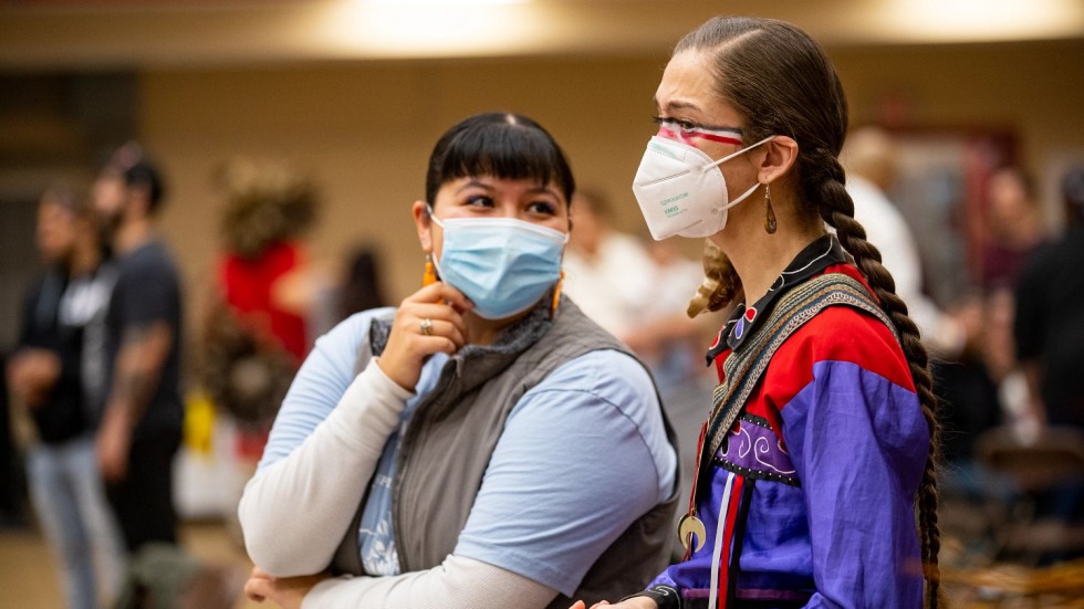 two masked people having a conversation