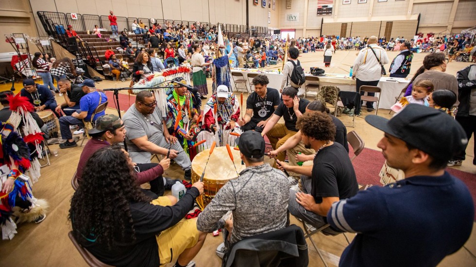 men sitting in a circle and drumming