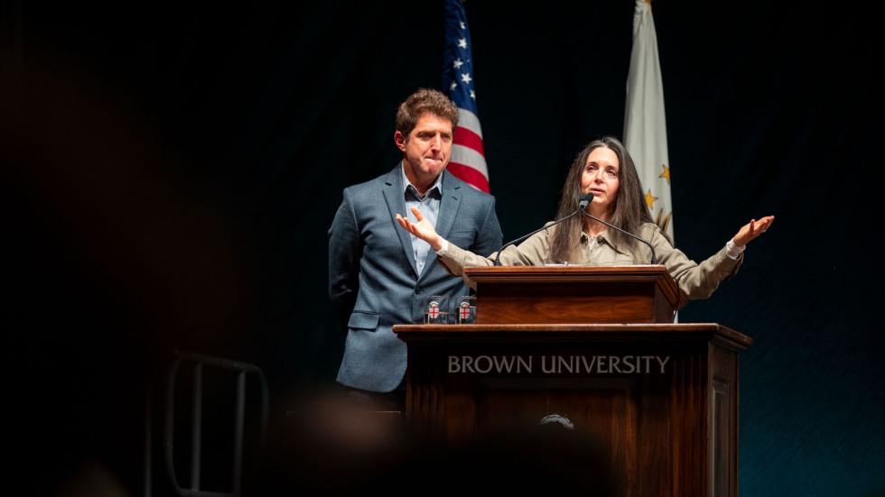 woman holding her arms out wide at a podium