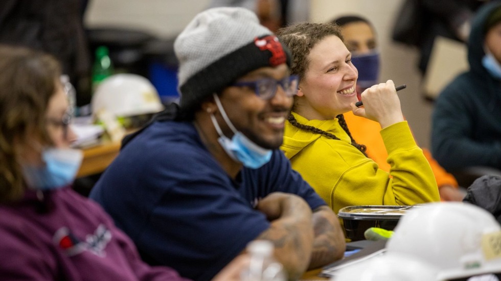 students sitting at a long table and smiling