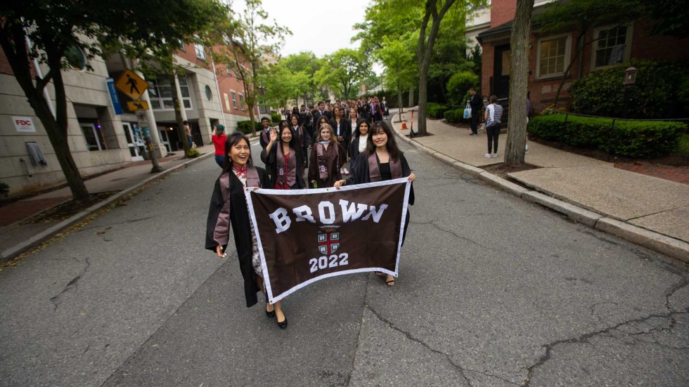 students carrying a banner and walking down an empty street