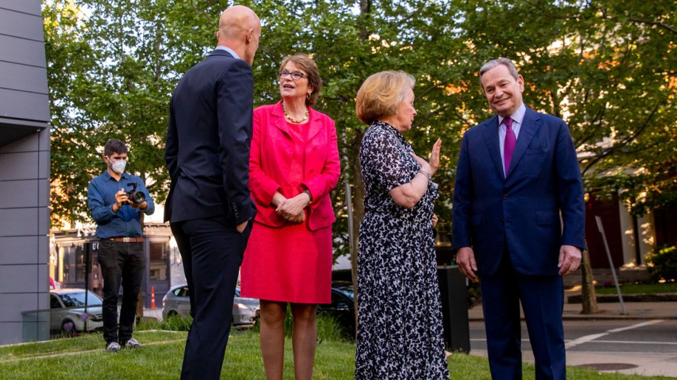 four people chatting on a lawn