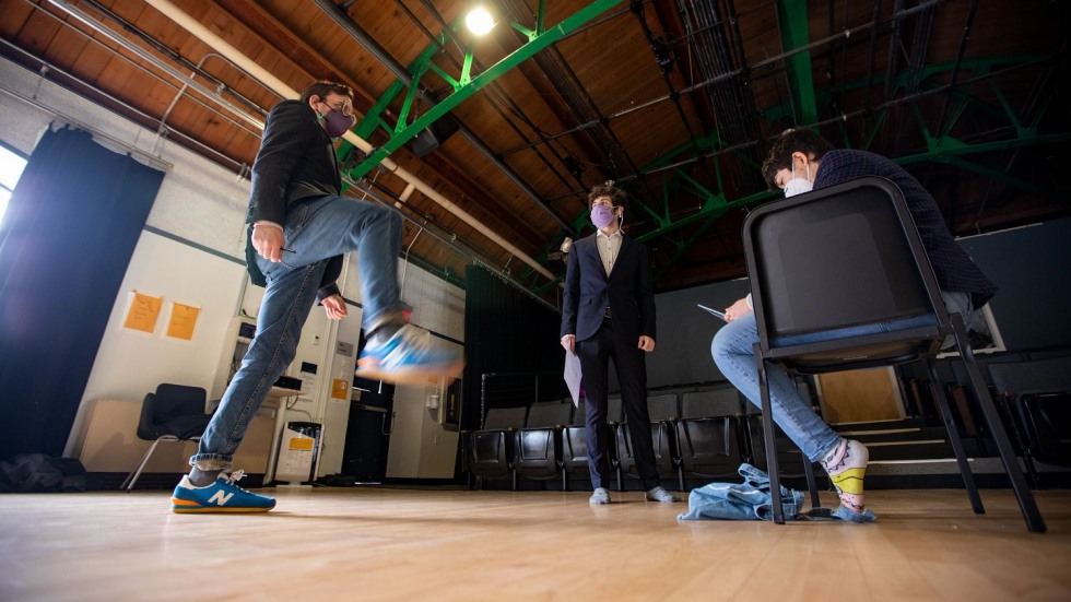 three people wearing blazers standing in a dance studio