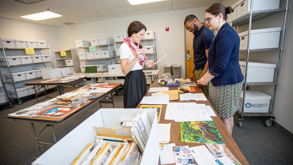 Mary Murphy, N'Kosi Oates and Amanda Knox looking at a table covered in documents