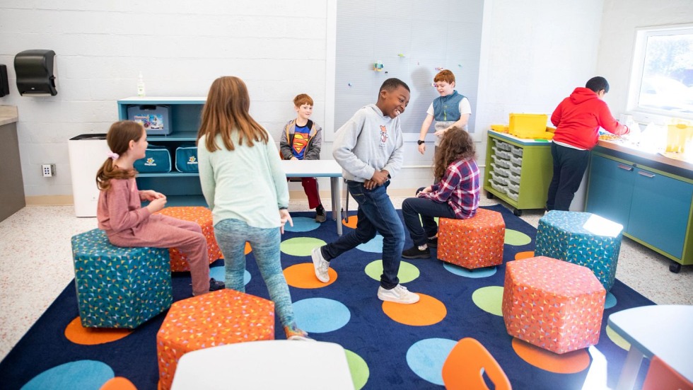 students interacting on fabric stools and playing with legos