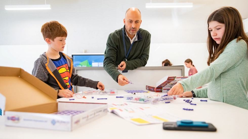 Matt Russo using a snap circuit with two fourth grade students