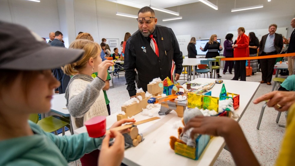 man watching students conduct an engineering experiment