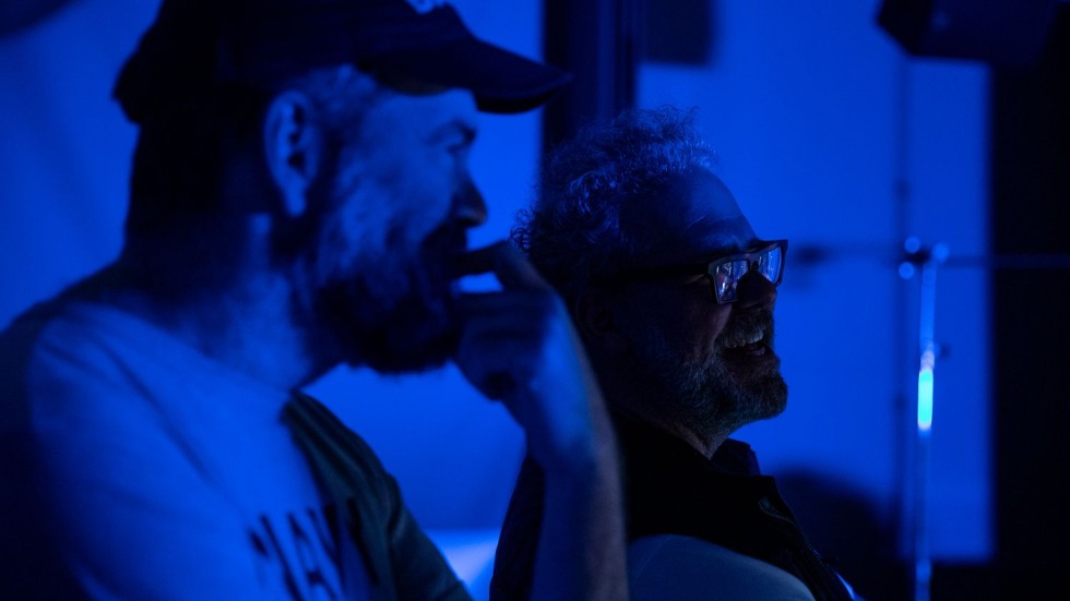 two people standing in a dark room