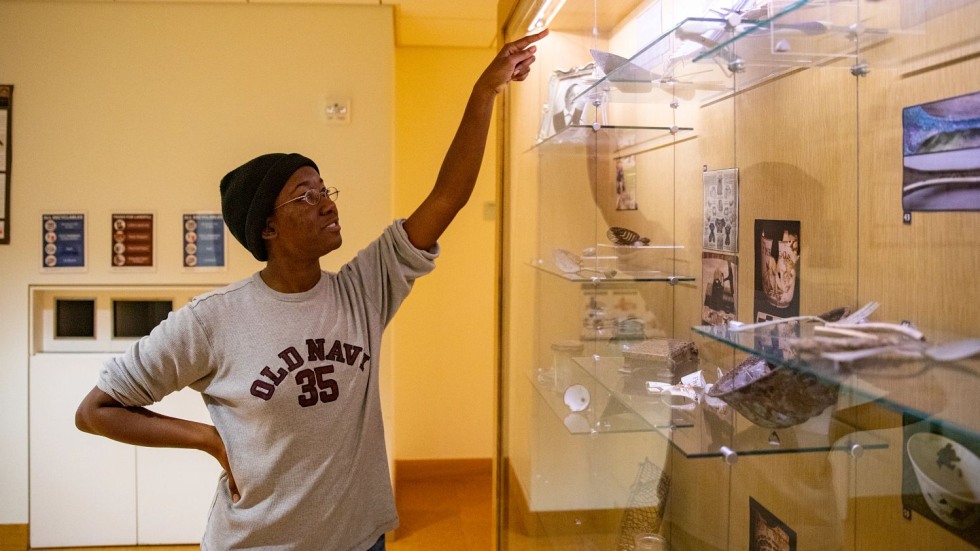 erynn bentley pointing to an object in a glass display case