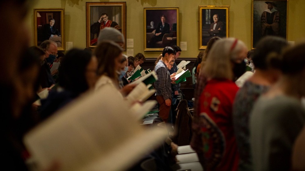 rows of people looking at sheet music and singing