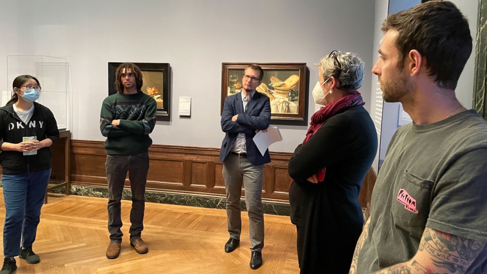 people standing in a circle in a museum painting gallery