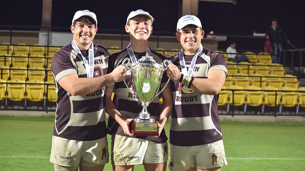 three players pose with trophy