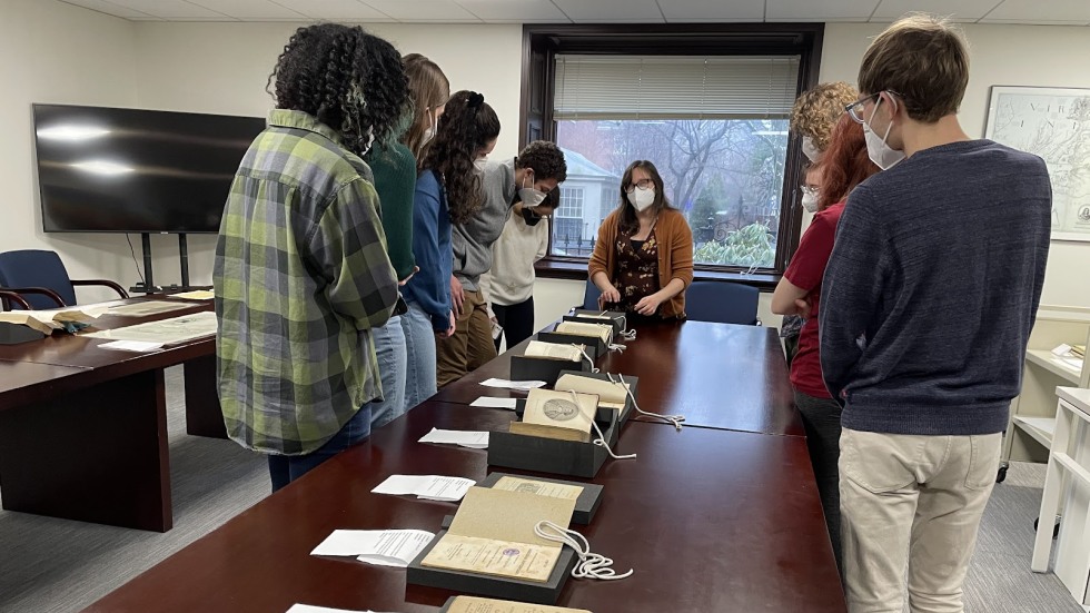 students gathered around a table looking at colonial documents