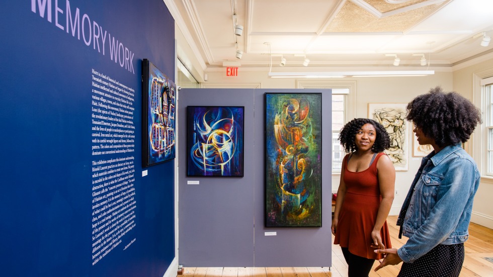 two students conversing at an exhibition at the CSSJ