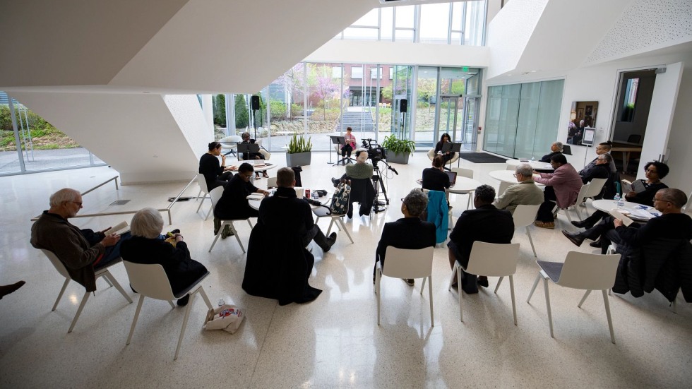 Seated people listening to a reading in Stephen Robert Hall