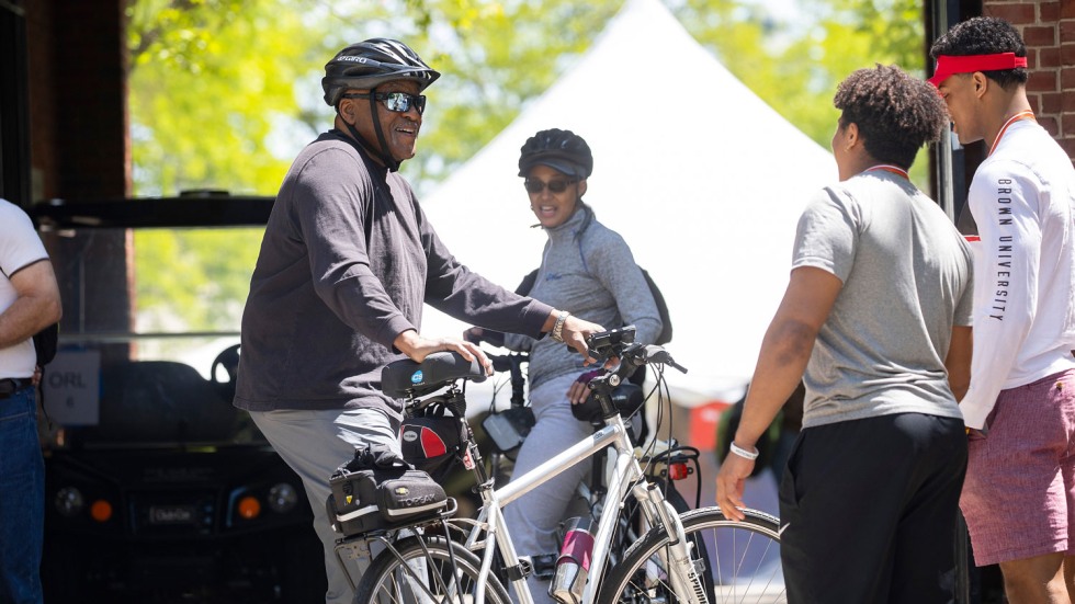 Leroy Cole riding a bicicle and talking to people