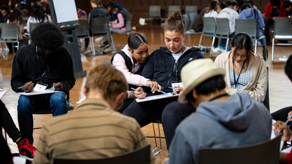 seated middle school students filling out a written survey