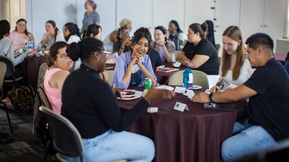 Students converse around a table