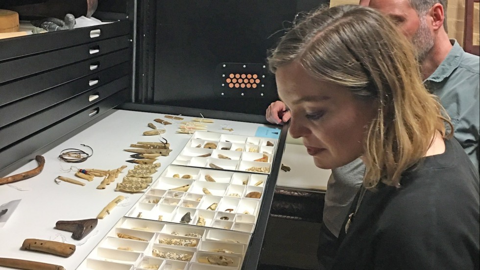 Sophie Rockwell looking at objects created by the Inupiat