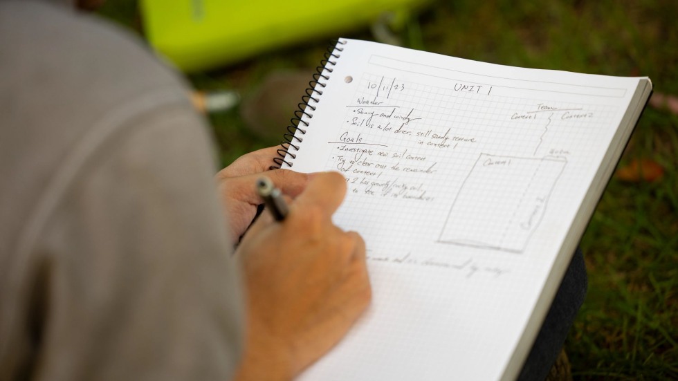 Student writes observations in a notebook