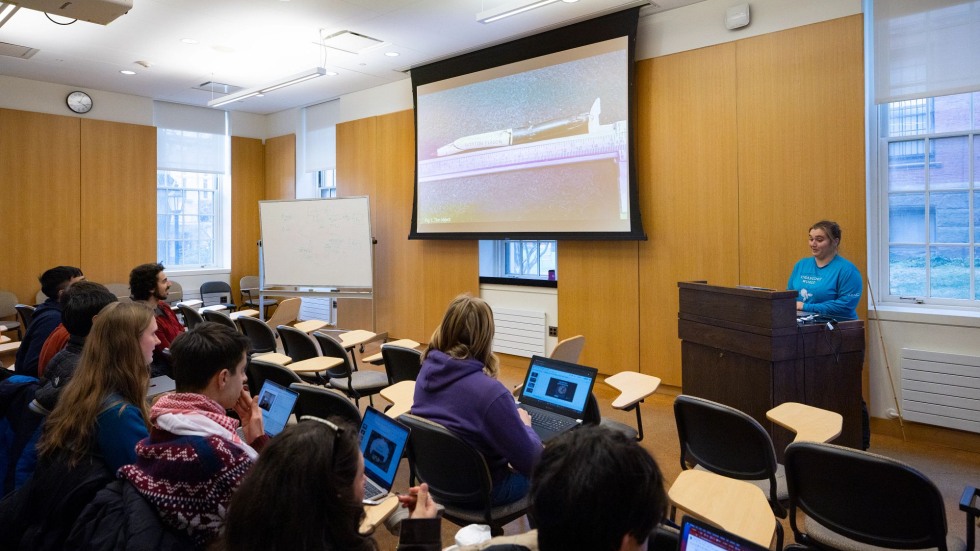 Student presents at a screen in a classroom