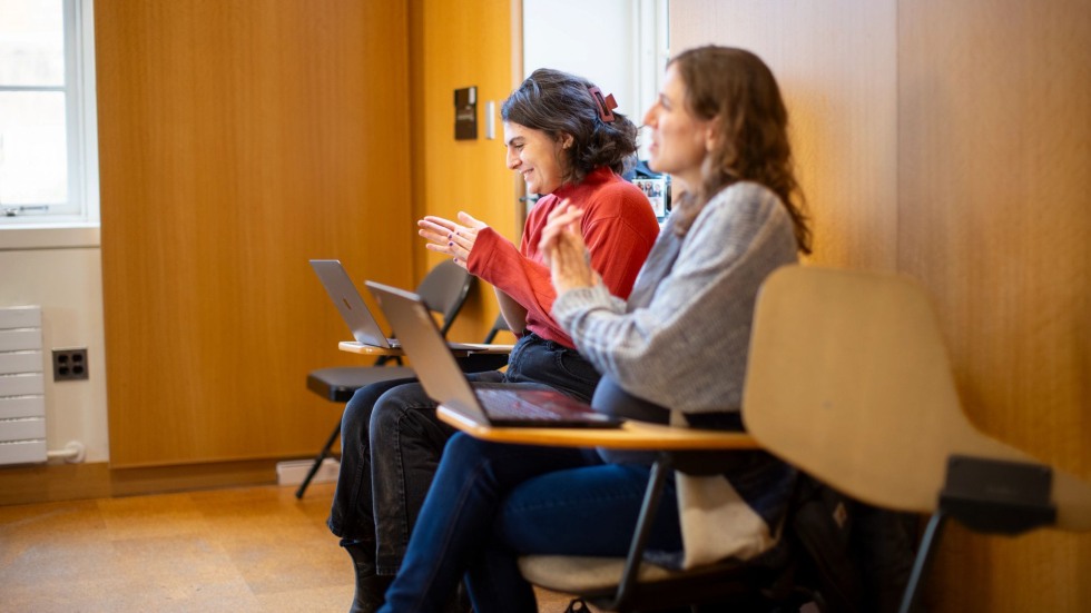 Leah Neiman and Liza Davis seated in class