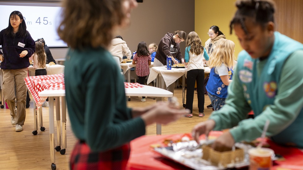 Brown students working with Girl Scouts to build gingerbread houses