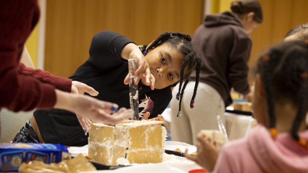young Girl Scout building gingerbread house