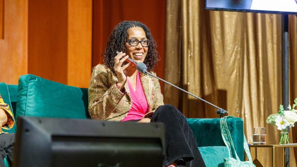 Johanna Fernandez holding her cell phone up to a microphone