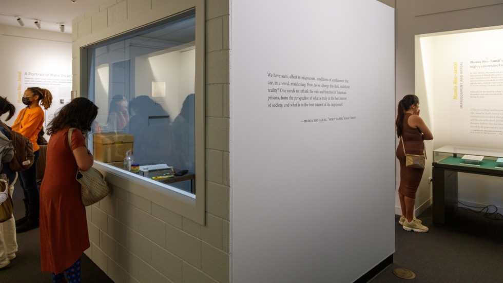 people viewing a replica solitary confinement cell in a library