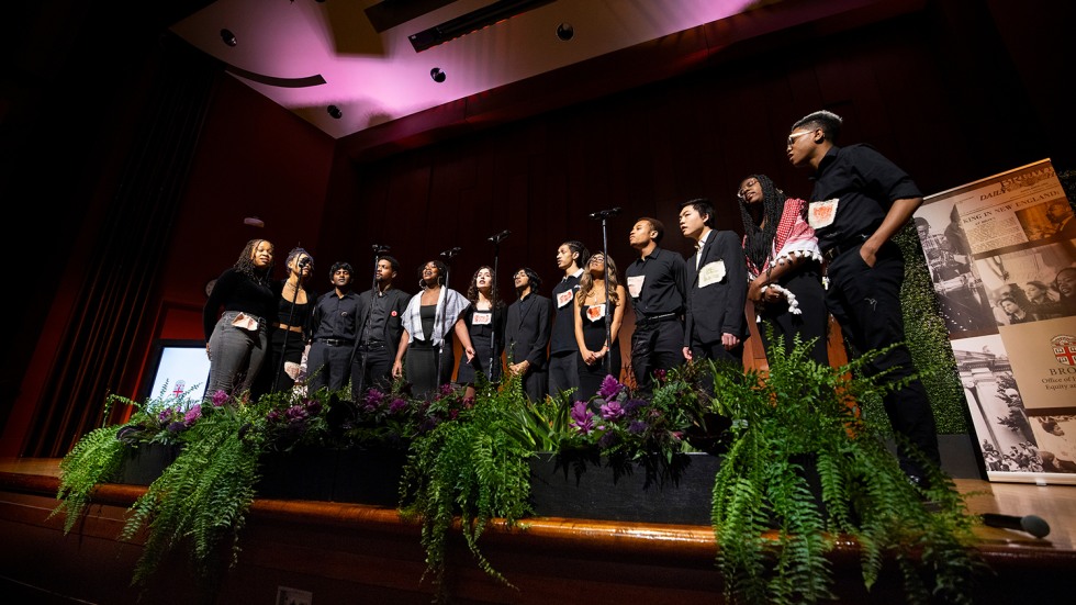 Students stand in a row and sing on stage