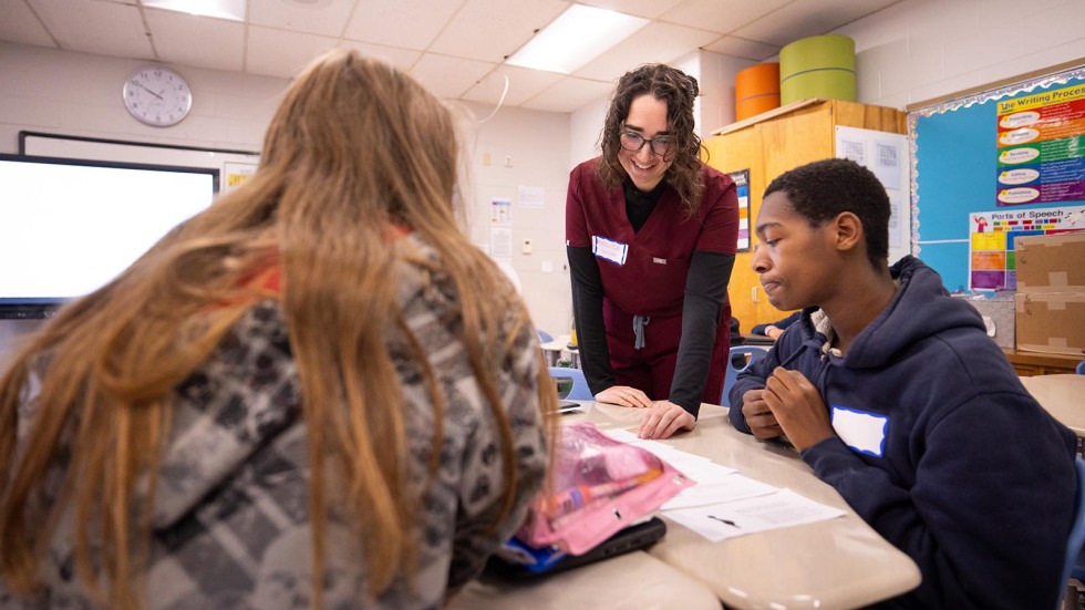 Brown medical student guiding middle schoolers on lesson 