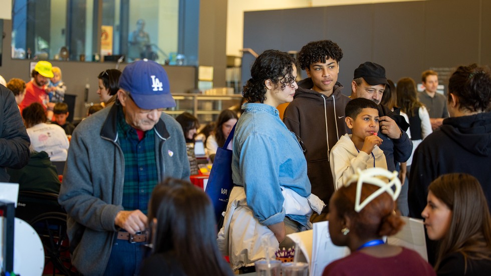 a family stops to listen to researchers at a table