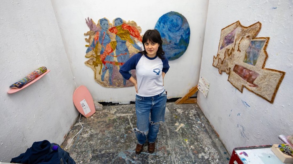 student posing with her art 