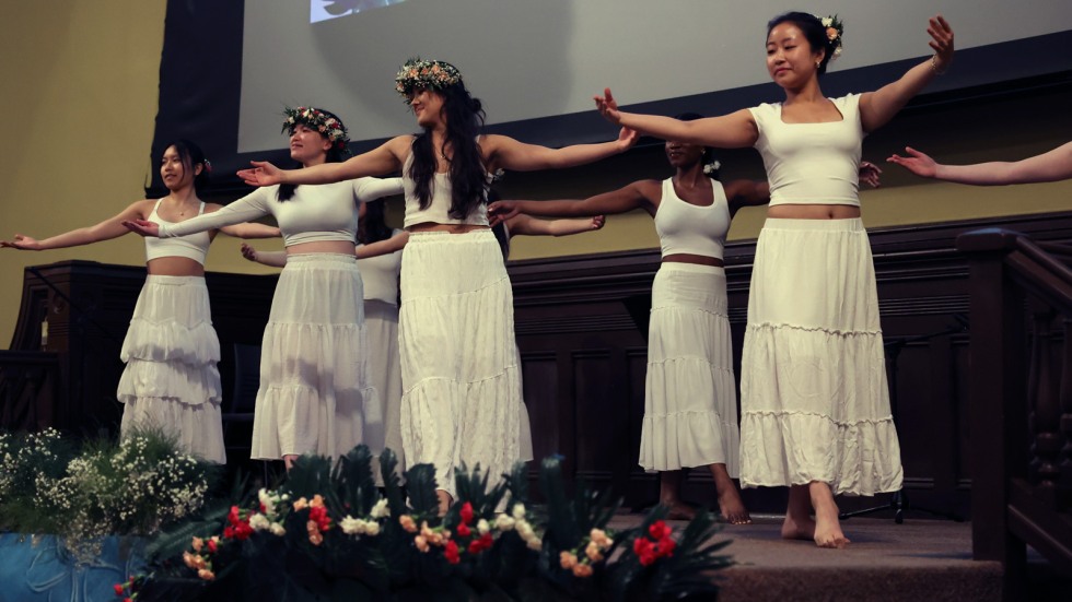 Hula dancers in all white on stage 