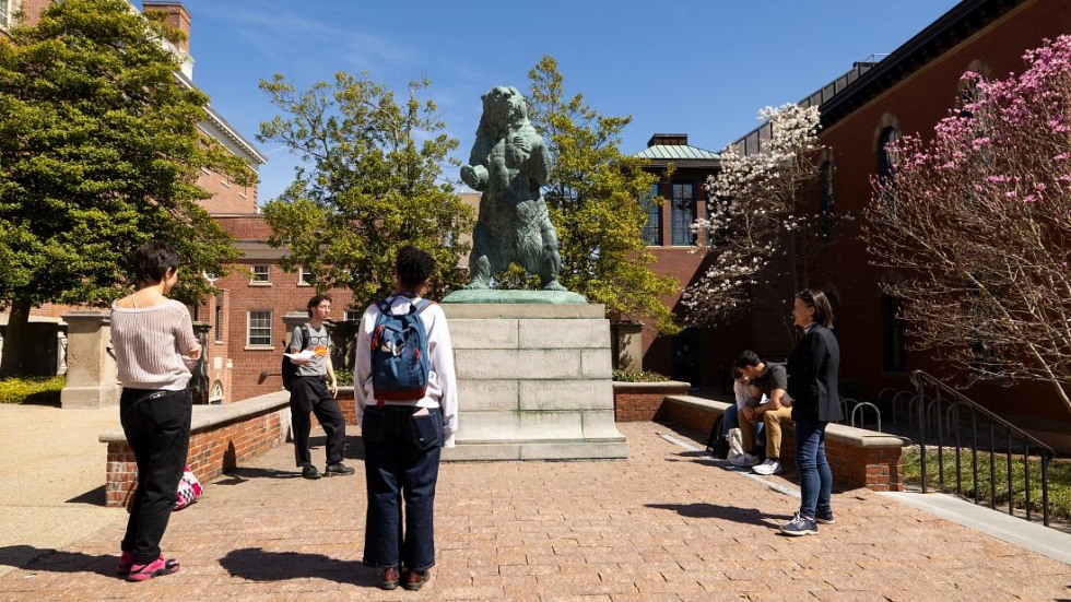 Students gathered around bear sculpture