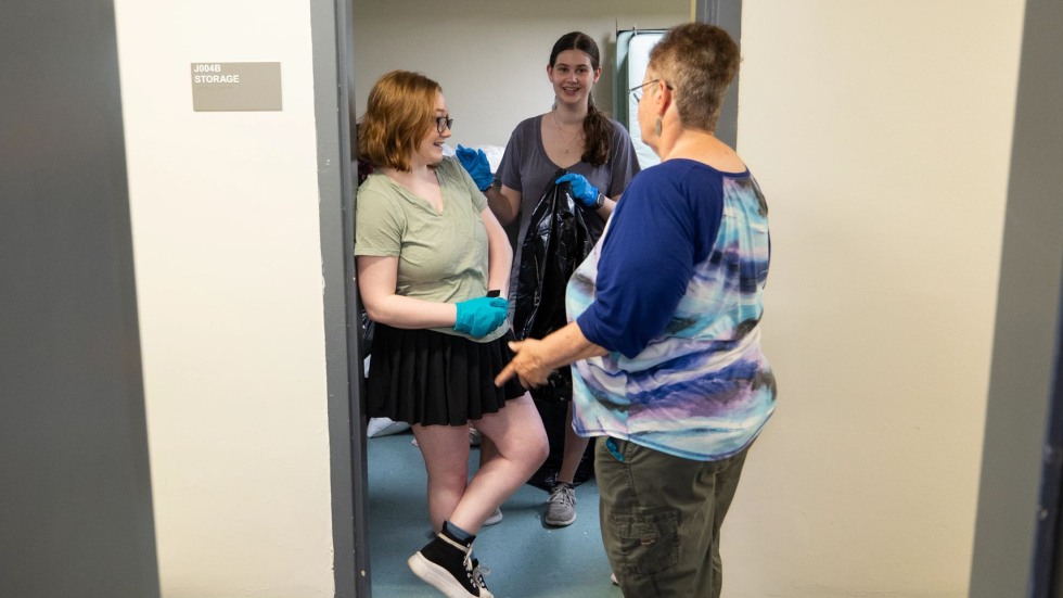 Three people talking in a doorway