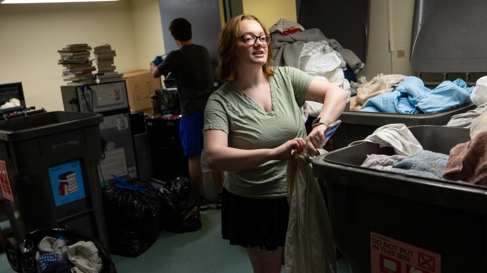 Hannah Fernandez stands over a bin of donations
