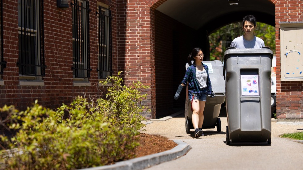 Two students wheel donation bins