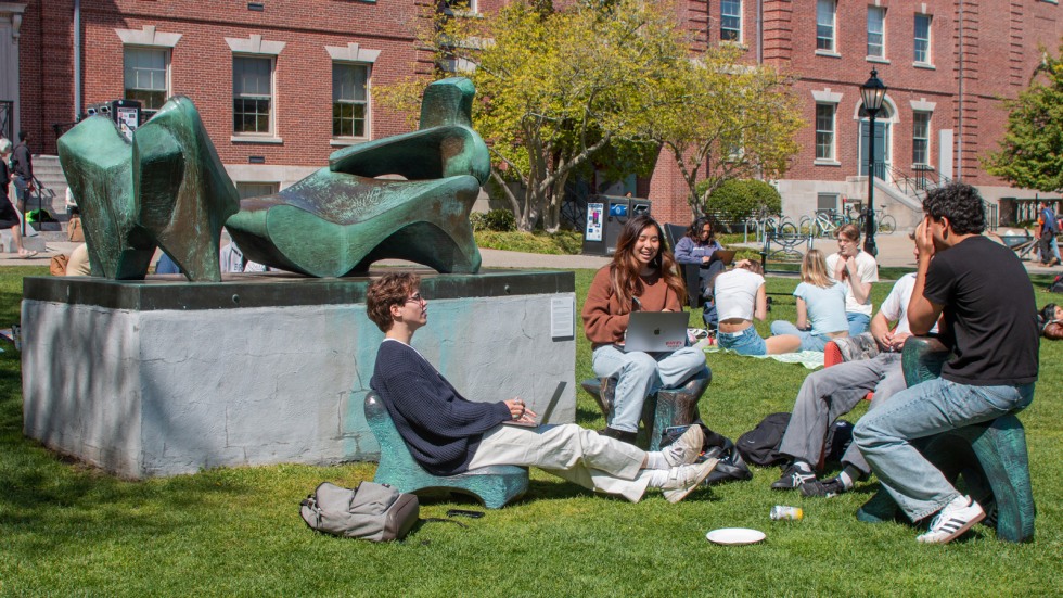 Students sit on chair sculptures