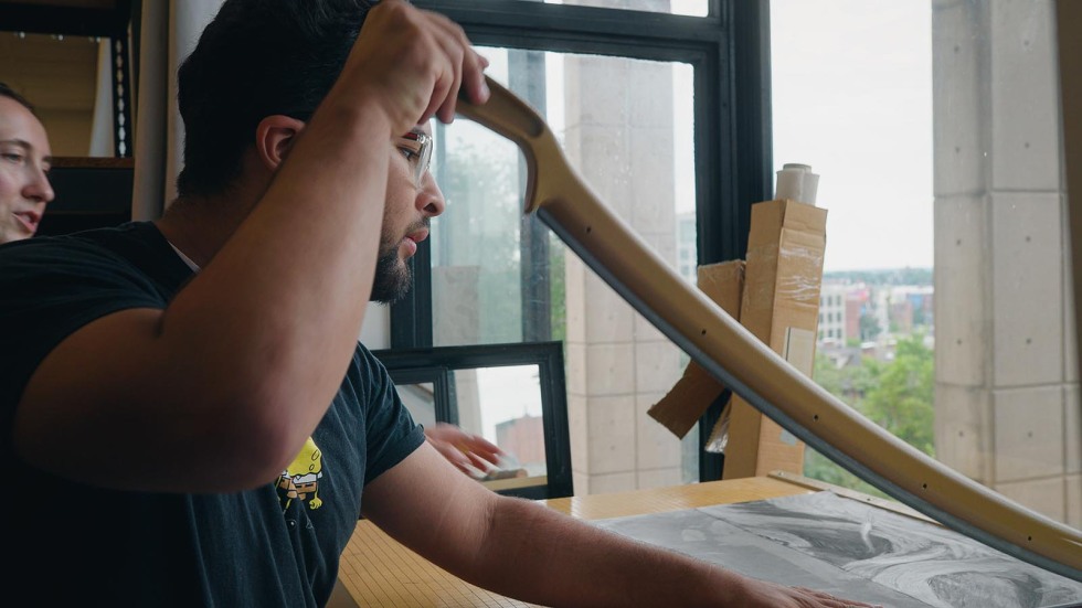 PPSD student practices with a paper cutter in a drawing course