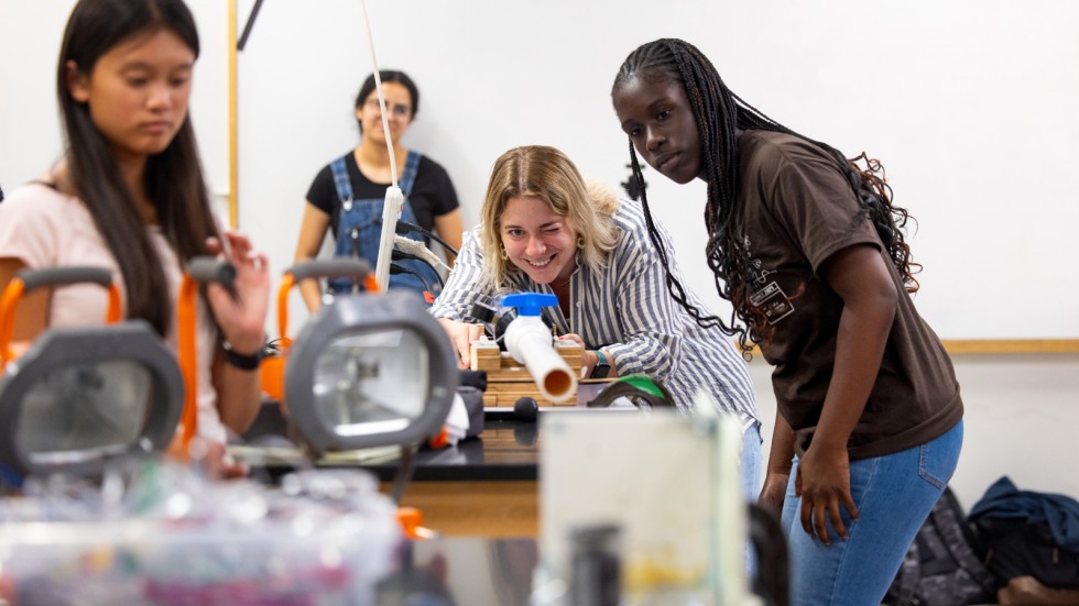 Students launch balls through PVC tube and capture images with high speed camera