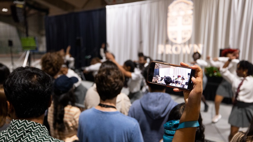 Students watching a performance and recording