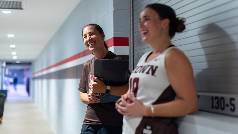 Coach Britt Broady and teammate Lizzie Loftus stand in the OMAC hallway