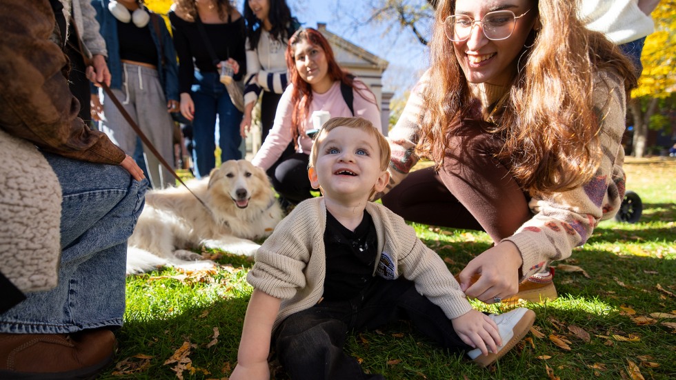 Attendees pet a therapy dog on the College Green