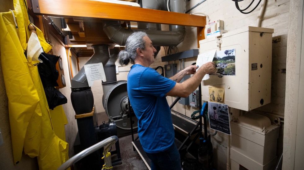 Joseph Rotella adjusts a wall instrument
